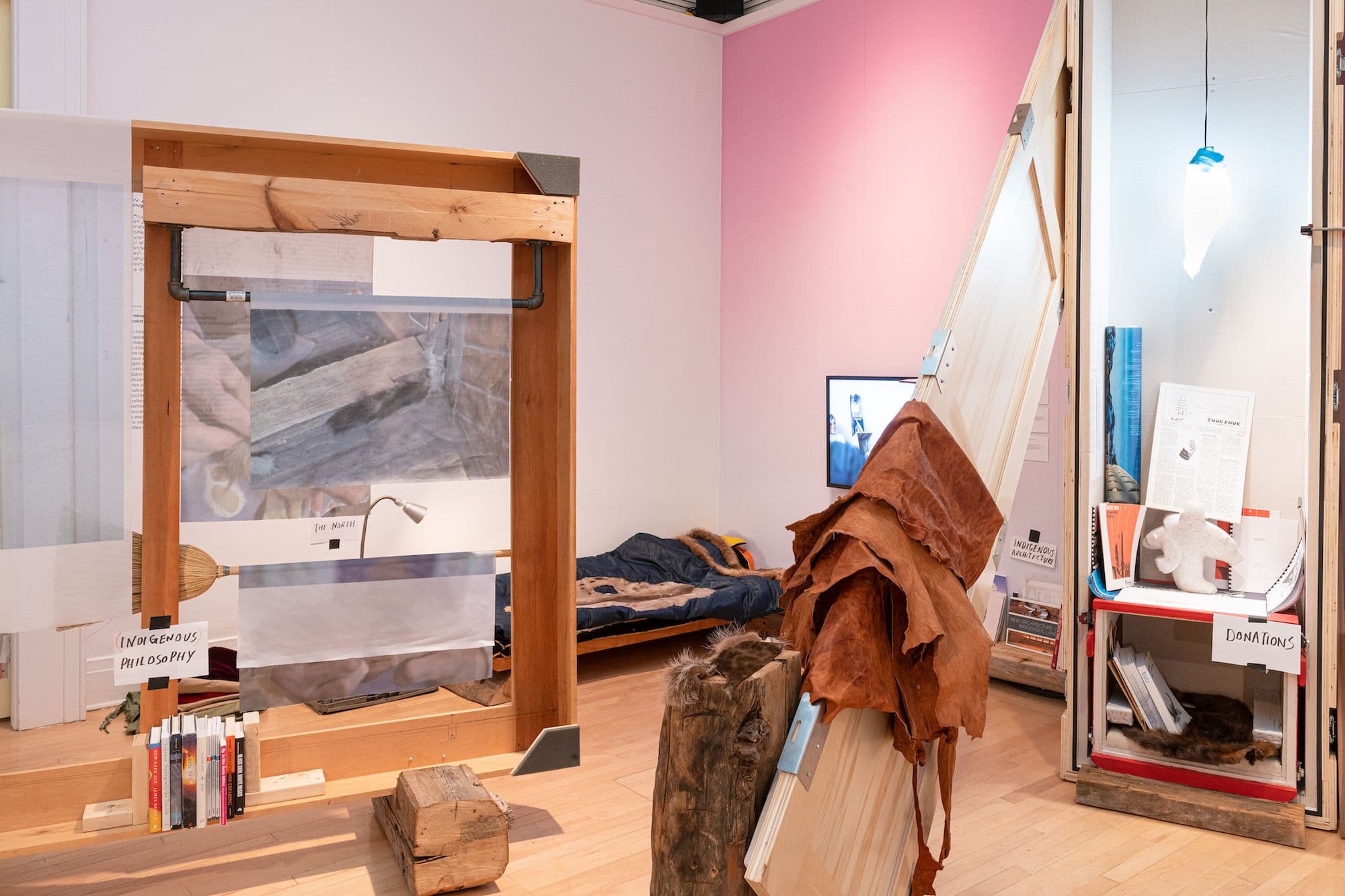 Studio space with various storage and display areas and a bed in the corner. 